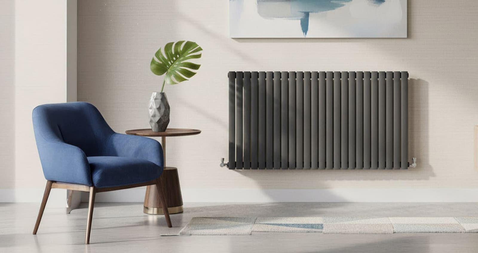 An anthracite horizontal column radiator on a pale wall in a living room, beside a blue armchair